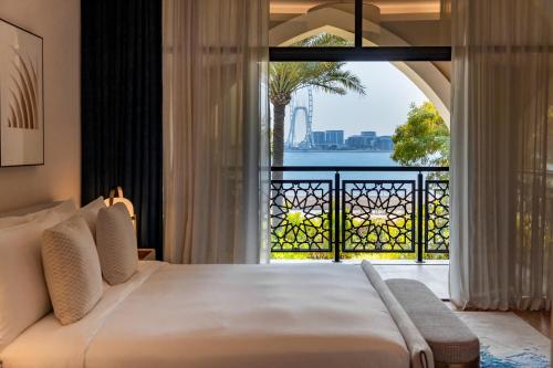 a bedroom with a bed and a view of the ocean at Jumeirah Zabeel Saray Dubai in Dubai