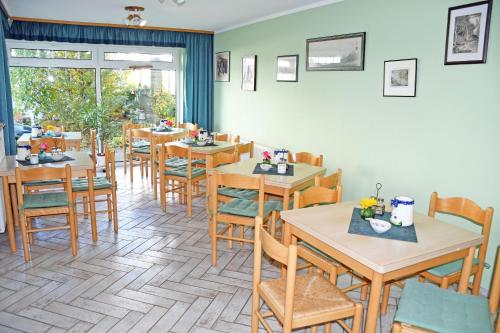 a dining room with wooden tables and chairs at Pension Seeperle in Sandort