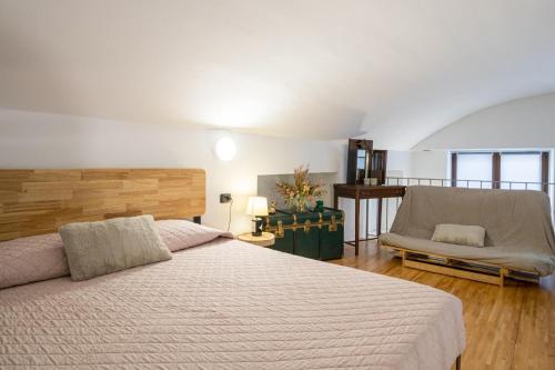 a bedroom with a large bed and a chair at Albavilla Stone Loft in Albavilla
