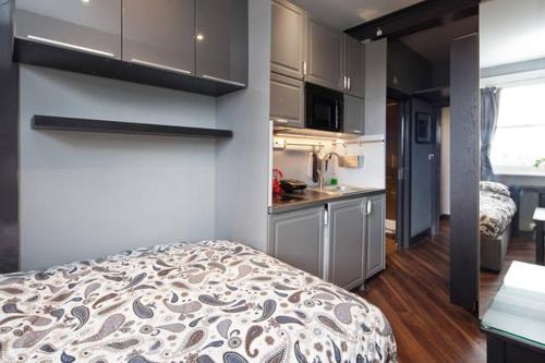 a small room with a bed and a kitchen at Sabellis House - Moments from the Big Ben in London