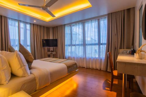 a hotel room with a bed and a desk at Coconut Tree Hulhuvilla Beach in Hulhumale