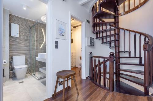 a hallway with a spiral staircase and a toilet at The Blue Door - Skopelos in Skopelos Town