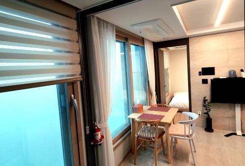 a room with a table and chairs and a window at 광안리 오션뷰 in Kwangan-dong