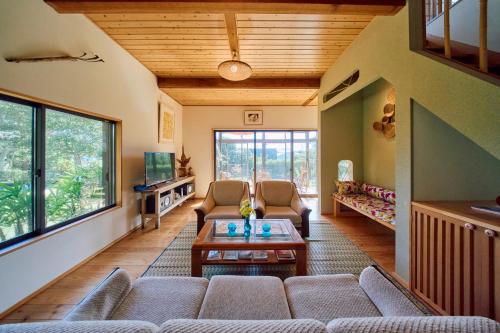 a living room with a couch and a table at Villa EDEN 南房総 - Private Stay Garden BBQ in Minamiboso