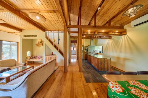a living room with wooden ceilings and a staircase at Villa EDEN 南房総 - Private Stay Garden BBQ in Minamiboso