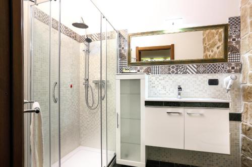 a bathroom with a shower and a sink and a mirror at Bienestar - Maison de Charme in Alghero