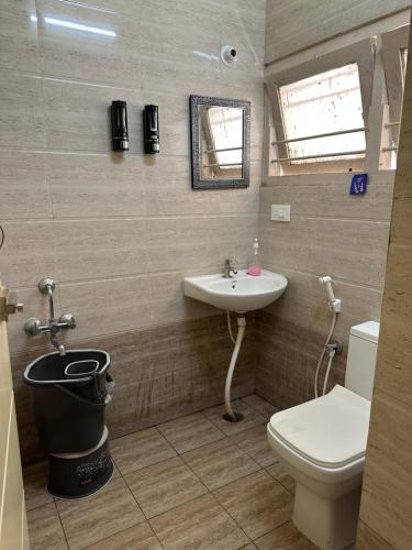 a bathroom with a toilet and a sink at Raaha Residency in Mysore
