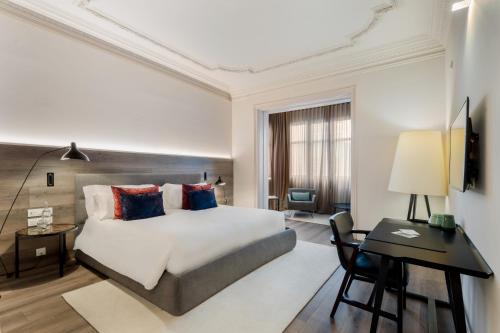 a hotel room with a bed and a desk and a room at Casagrand Luxury Apartments Barcelona in Barcelona