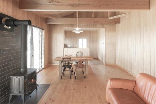 a living room with a fireplace and a table with chairs at Amakusa Retreat House - 天草リトリートハウス - in Amakusa