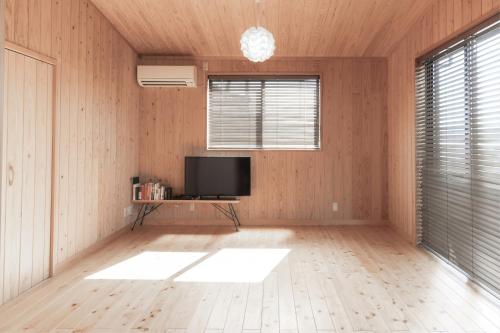 a living room with a television and a wooden floor at Amakusa Retreat House - 天草リトリートハウス - in Amakusa