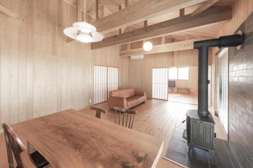 a living room with a table and a wood stove at Amakusa Retreat House - 天草リトリートハウス - in Amakusa