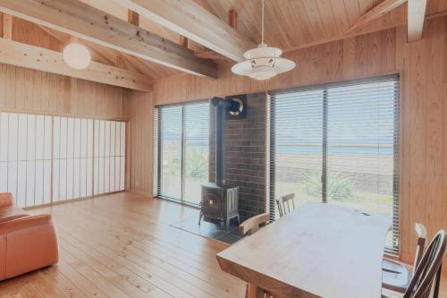 a living room with a table and a fireplace at Amakusa Retreat House - 天草リトリートハウス - in Amakusa