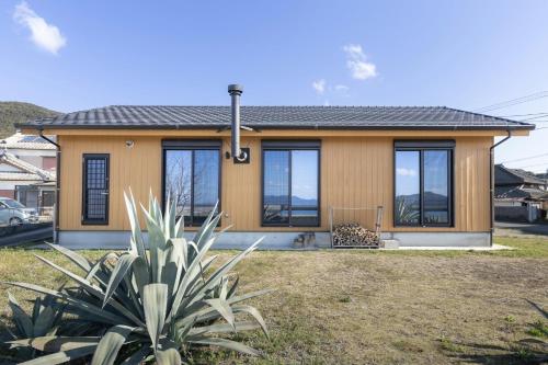 a house with windows and a plant in front of it at Amakusa Retreat House - 天草リトリートハウス - in Amakusa