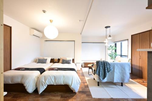 a bedroom with two beds and a table at EN Matsubara in Kagoshima