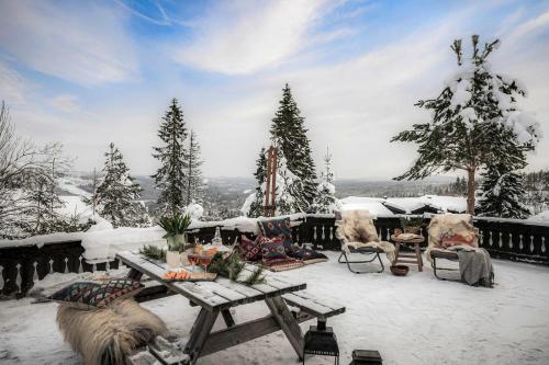 a snow covered patio with a picnic table and chairs at TH622- Premium ski-in,out Chalet with 8 bedroom, jacuzzi, sauna in Hovi