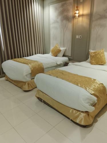 two beds in a hotel room with at Golden New Muhayil-نيلولوفر فور in Ḑirs