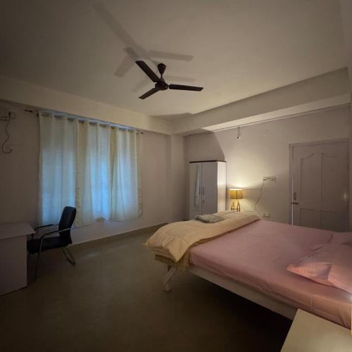 a bedroom with a bed and a ceiling fan at Silo namlo 2BHK in Duimukh