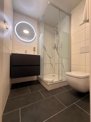 a bathroom with a shower and a toilet and a sink at Spree - Waldhotel Cottbus in Cottbus