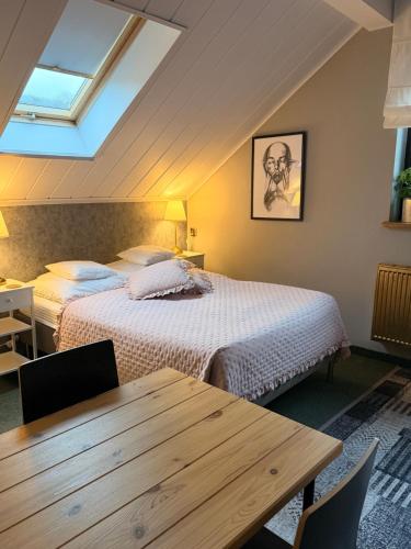 a bedroom with two beds and a wooden table at Dziki Szynk in Brenna