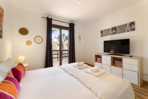 a bedroom with a white bed and a tv at Casa del Jable in Parque Holandes