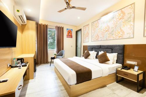 a hotel room with a bed and a flat screen tv at asar Varanasi Junction by Orion Hotels in Varanasi