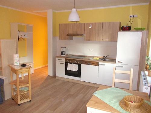a kitchen with white appliances and wooden cabinets at FeWo Schwalbennest in Marlow