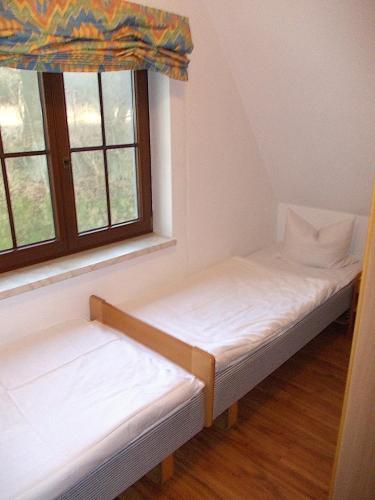 two beds in a room with a window at Finnhaus Annika in Marlow