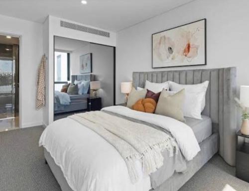 a bedroom with a large bed with white sheets and pillows at Olympic Optimum Accor in Sydney