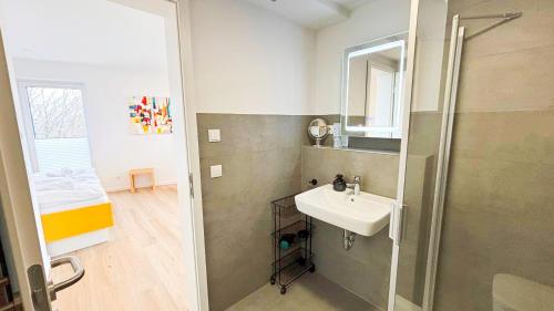 a bathroom with a sink and a shower at Stadtloft Penthouse "Eversten" Neubau Business Apartments für Projekt- und Firmenaufenthalte in Oldenburg
