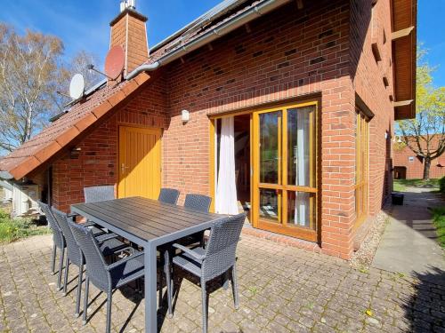 a patio table and chairs in front of a brick house at Haus 2 Naturerlebnisse und Erholung im Natur Ferienpark in Nieheim