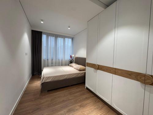 a bedroom with a bed and a large window at Modern apartment in Yerevan