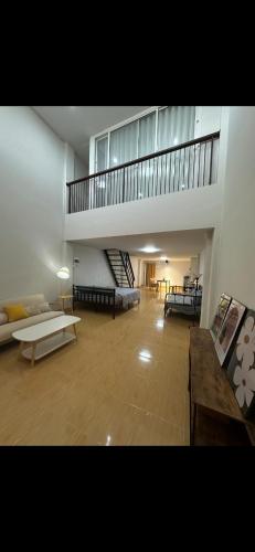 a large living room with a staircase in a building at Quiet place with duplex room in Ban Kohong