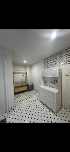 a room with a white cabinet and a black and white tiled floor at Quiet place with duplex room in Ban Kohong