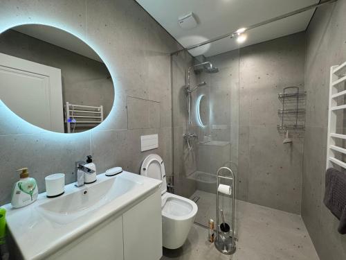 a bathroom with a sink and a toilet and a mirror at Modern apartment in Yerevan