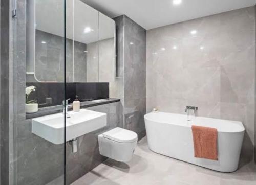 a bathroom with a tub and a toilet and a sink at Olympic Optimum Accor in Sydney