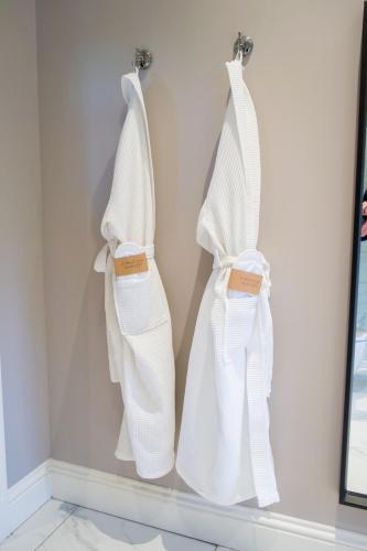 two white slippers hanging on a wall at Snowdrop Lodge in Errol