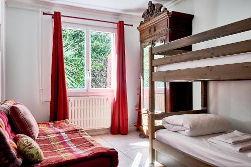 a bedroom with a bunk bed and red curtains at Villa Le Deck - Grande maison familliale proche plage in Arcachon