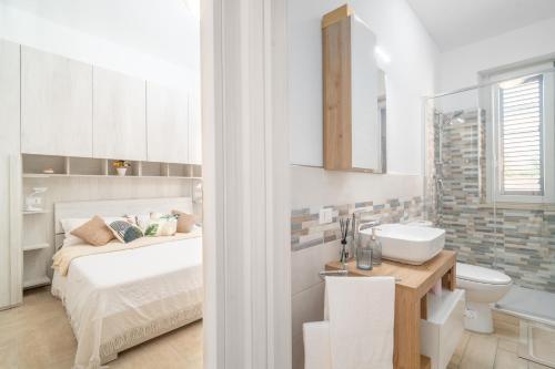 a white bathroom with a bed and a sink at New Apartment Piombino wifi parking in Piombino