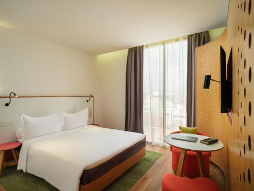 a hotel room with a bed and a desk and a table at MU Hotel in Ipoh