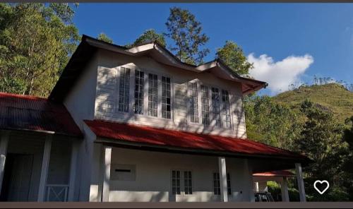 a white house with a red roof at GP Estate Bungalow in Suryanelli