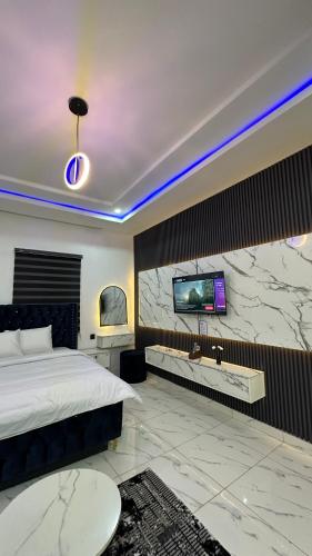 a bedroom with a bed and a tv on a wall at TWR Abuja Partner #Blessing in Abuja
