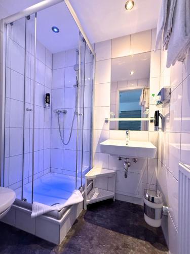 a bathroom with a shower and a sink and a toilet at Hotel Hohenstaufen in Koblenz