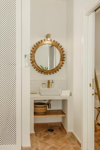 a bathroom with a sink and a mirror at Casa do Sol - Casas do Levante in Olhão