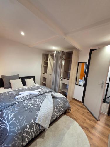 a bedroom with a bed with a blue comforter at MAISON LA SOURCE d'hôte à Roubaix in Roubaix