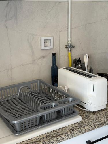 a dish drying rack on a counter next to a toaster at Le gris Perle in Sfax