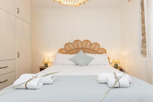 a bedroom with a large white bed with towels on it at Aila Stay in Corfu