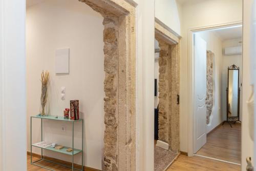 a hallway with a stone pillar and a glass shelf at Aila Stay in Corfu