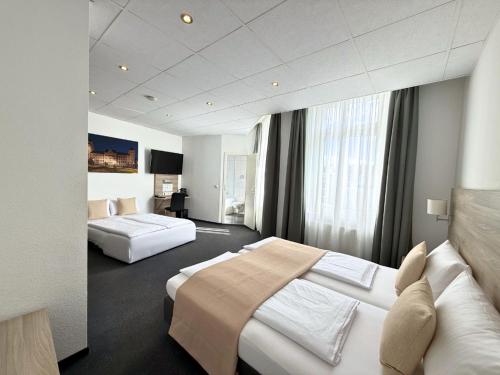 a hotel room with two beds in a room at Hotel Hohenstaufen in Koblenz