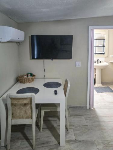 a dining room with a white table and chairs at Studio Efficiency Apartment - a peaceful retreat in Port St Lucie in Port Saint Lucie
