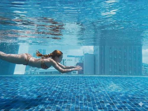 a woman swimming in the water in a swimming pool at Hotel Aqua Citta Naha in Naha
